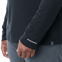A close-up of a dark navy quarter-zip jacket featuring a reflective detail on the sleeve and a subtle logo.