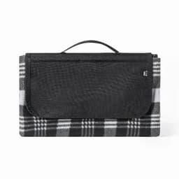 A picnic blanket in black and white plaid, folded with a black carry handle on top. Features a logo on the side.