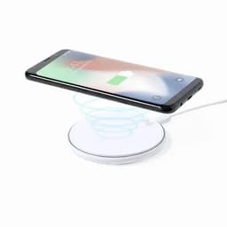 A wireless charging pad in white with a smartphone placed on top, indicating it is charging.