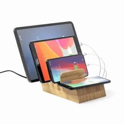 A charging station with a wooden base, holding multiple devices including a tablet and two smartphones.