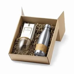 A gift box containing a silver drink bottle with a wooden accent and a clear glass container, all nested in shredded packaging.