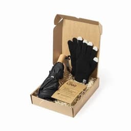 A gift box containing a black umbrella and black gloves with white tips, arranged with straw.