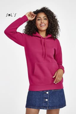 A unisex hoodie in vibrant pink, featuring a front pocket and a hood, worn with a denim skirt.