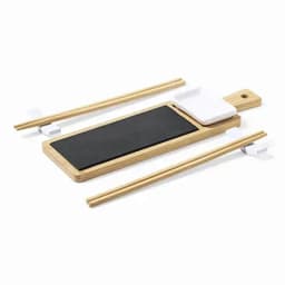 A serving platter made of wood and black slate, accompanied by chopsticks and a small white condiment holder.