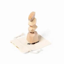 A stacking game with wooden geometric shapes in natural tones, placed on a drawstring pouch.