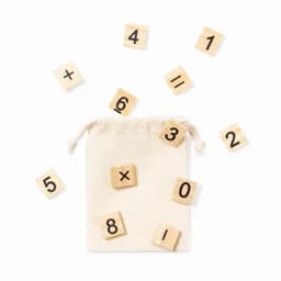 A canvas drawstring bag with wooden number tiles scattered around, featuring natural wood colour with black numbers.