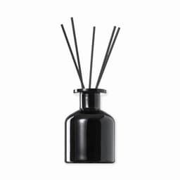 A black aroma diffuser with five black reeds arranged in a circular holder. The bottle has a sleek, modern design.