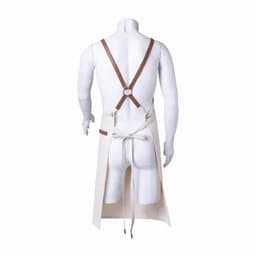 A cream-coloured apron with brown straps, featuring a stitched pocket and a tie at the waist.