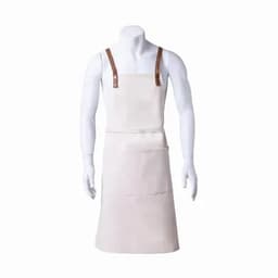 A cream-coloured apron with leather straps and front pockets, displayed on a mannequin.