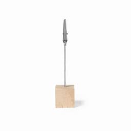 A wooden block with a metallic clip attached by a thin cable, forming a simple display stand.