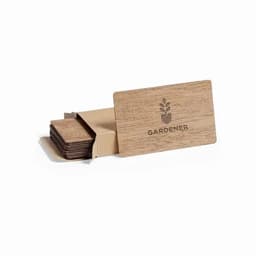 A set of wooden coasters in a cardboard holder, featuring a floral logo on the front. The coasters are a natural wood colour.