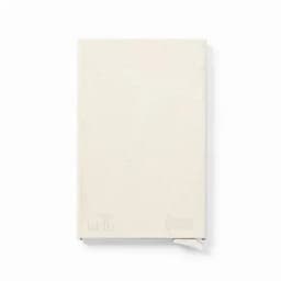 A notebook with a textured cream cover and a ribbon bookmark. It features a logo on the lower right corner.