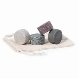 A set of four round stones in various shades, resting on a cloth pouch with drawstrings.