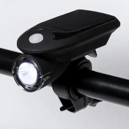 A bike light featuring a solar panel and a bright front LED, attached to a black handlebar.
