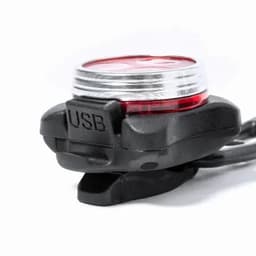 A USB light with a red lens and black casing, featuring a cap on the connector. It has a logo on the side.