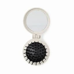 A compact mirror with a round hair brush, featuring a black bristle design and a simple natural-coloured casing.