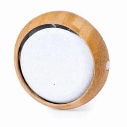 A round product with a bamboo exterior and a smooth white interior, featuring a small button on the side.