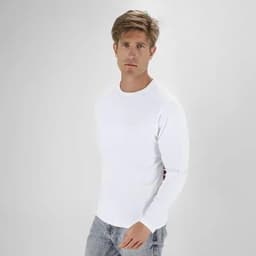 A casual white long-sleeve shirt worn by a man, paired with light grey jeans. The model stands against a plain background.