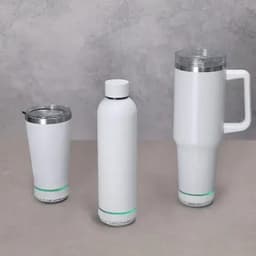 Three insulated mugs in white, featuring silver accents and a green base line, all with logos.