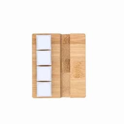 A bamboo serving board with three white ceramic bowls neatly arranged on it.