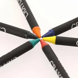 A collection of six crayons in vibrant colours—orange, blue, green, red, and yellow—arranged in a circular pattern.