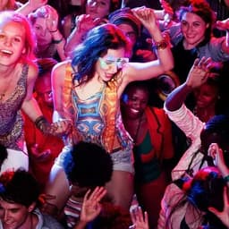 A lively crowd dancing at a party, filled with vibrant colours and diverse outfits, showcasing excitement and energy.