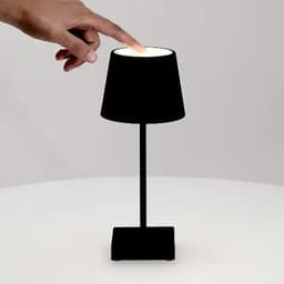 A black lamp with a lampshade is shown, featuring a finger touching the top to turn it on.