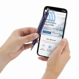 A pen in hand with a smartphone displaying a website. The pen is blue, and the phone screen shows engineering solutions.