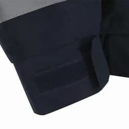 A close-up of a navy blue jacket cuff featuring grey accents and a Velcro strap.