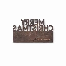 A decorative wall plaque with "MERRY CHRISTMAS" in cut-out letters and a circular hook at the bottom. It has a brown finish.