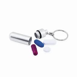 A metal pill container with a keyring, featuring various coloured capsules and tablets in purple, blue, and white.