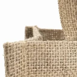 A natural jute bag featuring a woven texture and sturdy handles. The colour is light brown with a rustic finish.