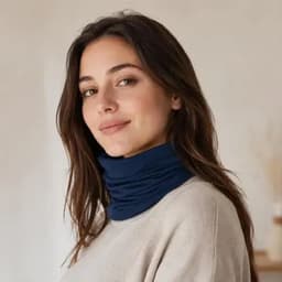 A woman wearing a navy blue neck warmer, styled casually with a light sweater, featuring a soft, versatile design.