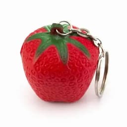 A red strawberry-shaped keychain with a green stem detail. The keychain includes a silver metal ring.