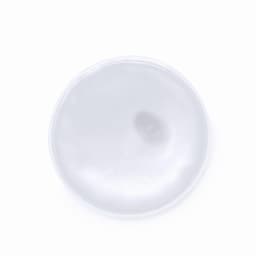 A round, glossy white surface with a subtle sheen, featuring a textured centre.