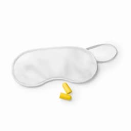 A white sleep mask and two yellow earplugs, featuring a simple design and soft fabric.