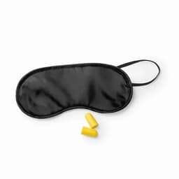 A black sleep mask with a black strap and two yellow earplugs beside it.