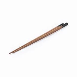 A pair of wooden chopsticks in a light brown colour with black tips and subtle design details.