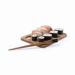 A wooden board holds various sushi pieces, including nigiri and rolls, alongside a pair of chopsticks.