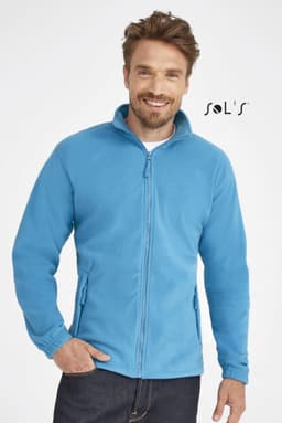 A zipped fleece jacket in bright blue, featuring a high collar and side pockets, modeled by a smiling man.