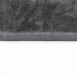 A grey towel with a plush texture and a stitched hem at the bottom.