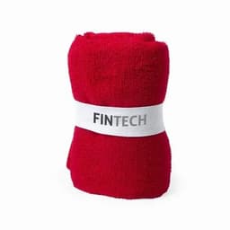 A red towel rolled and secured with a white band featuring a logo.