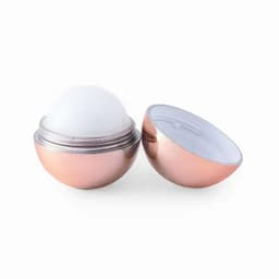 A cosmetic container in a rose gold hue, displaying a round, white balm inside with a split design.