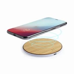 A wireless charging pad with a wooden surface and a smartphone hovering above it, emitting charging waves.