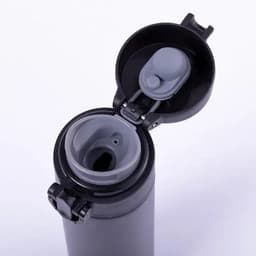 A drink bottle in black with a grey lid, featuring a flip-open top for easy access.