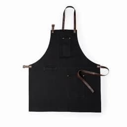 A black apron featuring multiple pockets and brown leather straps. It has a simple, functional design.
