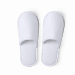 A pair of white spa slippers with a soft texture and open toe design. They have a simple, classic shape.