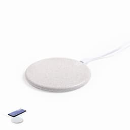 A wireless charging pad in a smooth, light grey finish. It features a cable connected to its base.