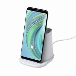 A phone dock with a white base and vertical stand, holding a smartphone with a colourful screen display.