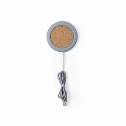 A round wireless charger with a cork surface and a grey rim, featuring a grey USB cable attached.